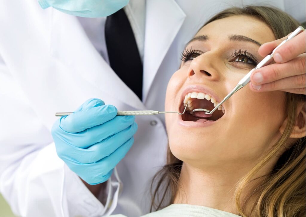 Dentist examining a patient's tooth during a dental checkup to diagnose what a cavity feels like and identify early tooth decay.