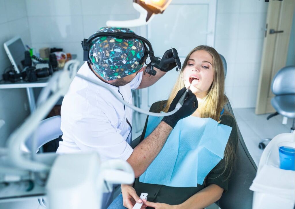 Dentist examining a patient's tooth under magnification to identify what a cracked tooth looks like during a dental evaluation.