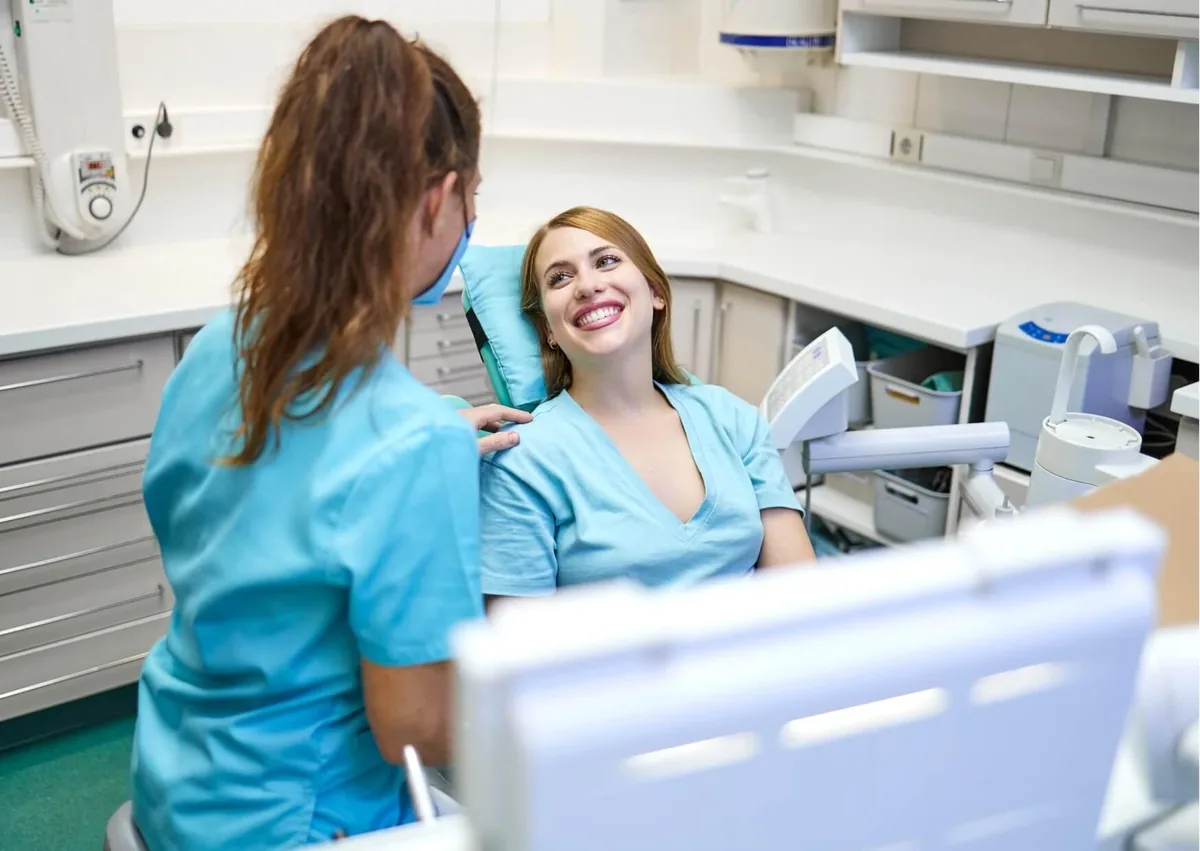 Patient smiling during a digital smile design consultation with a dental professional.