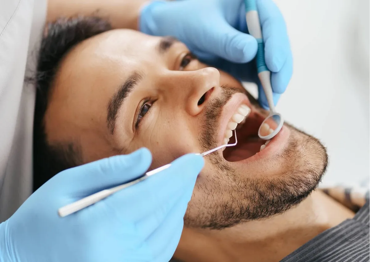 Dentist examining a patient’s teeth for signs of cavities during a dental checkup.