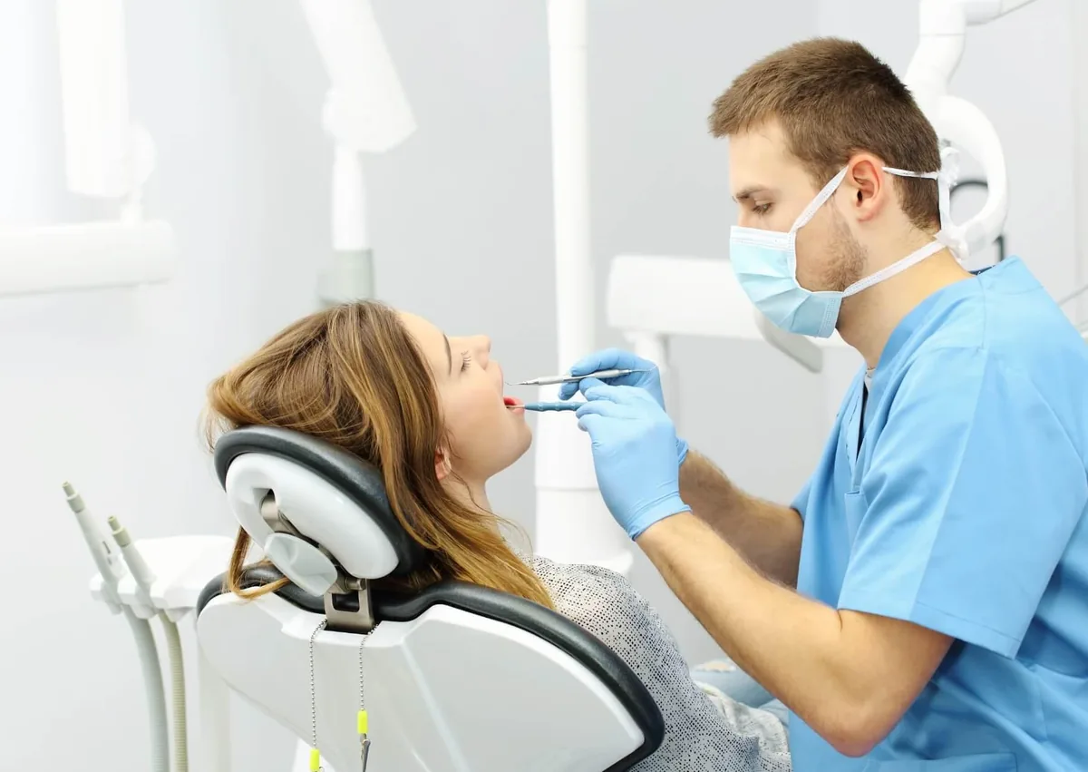 Dentist examining a patient’s teeth before a cosmetic teeth bonding procedure.